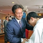 落選確実の一報を受け、支援者と握手を交わす五島大亮氏＝２６日夜、神戸市中央区八幡通２（撮影・鈴木雅之）