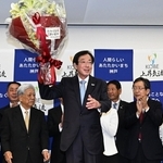 当選が確実となり、花束を持って喜ぶ久元喜造氏（中央）＝２６日夜、神戸市中央区の神戸国際会館（撮影・風斗雅博）