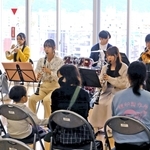 患者や住民の前で演奏を披露する県立大学の学生たち＝神戸市長田区二葉町５、野瀬病院