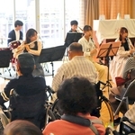 患者や住民の前で演奏を披露する県立大学の学生たち＝神戸市長田区二葉町５、野瀬病院