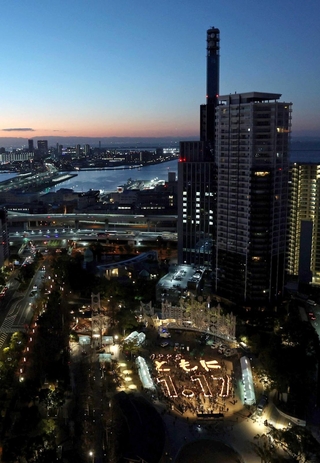 夜明けの神戸に、灯籠を並べて能登半島地震の被災者に寄り添う「１９９５　ともに　１・１７」の文字が浮かんだ＝２０２４年１月１７日、神戸市中央区加納町６、東遊園地