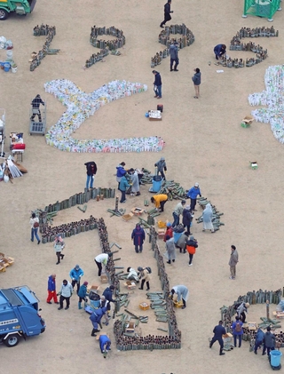 ボランティアらの手で片付けられる竹灯籠と紙灯籠＝２０２４年１月１８日、神戸市中央区加納町６、東遊園地