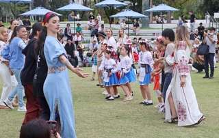 ウクライナから神戸市内に避難した女性（手前左）の指導の下、民族舞踊を踊る人たち＝２０２４年９月２９日、神戸市中央区加納町６、東遊園地