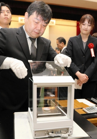 電子てんびんで記念貨幣の重さを計る職員＝大阪市北区天満１