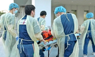 ドクターヘリで搬送されてきた患者を病院内に運び入れるスタッフら＝加古川市神野町神野、兵庫県立加古川医療センター