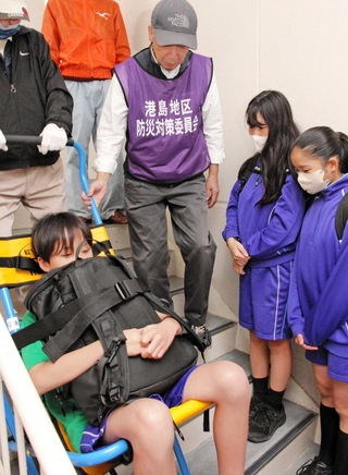 ポートアイランド住宅で階段避難車を体験する中学生ら＝神戸市中央区港島中町３