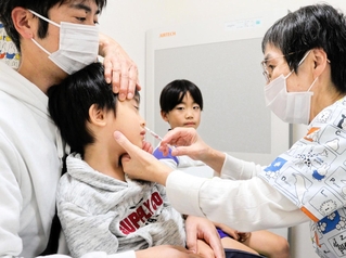 鼻の中にスプレーするタイプのインフルエンザワクチンの接種を受ける子どもたち＝神戸市垂水区学が丘７、たかのこどもクリニック