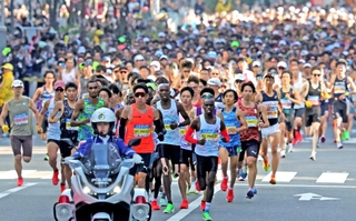 白バイに先導されて疾走する先頭集団＝１６日午前、神戸市中央区（撮影・笠原次郎）