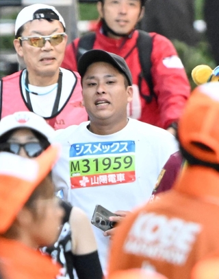 最終ランナーとなった秋本卓治さん＝１６日午後、神戸市中央区東川崎町１（撮影・斎藤雅志）