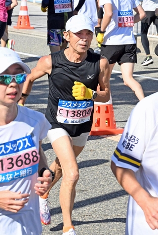 黄色い手袋をつけてコースを駆ける岡田雅宏さん（中央）＝１６日午前、明石市大蔵海岸通１（撮影・風斗雅博）