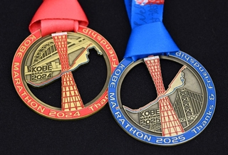 神戸マラソンの完走者メダル。右が２０２５年で左が２４年のもの
