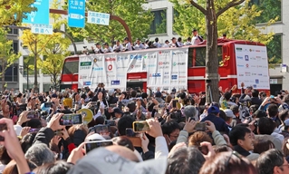 集まったファンの中を進む阪神ナインを乗せたパレードのバス＝大阪市中央区