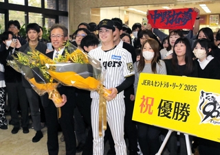 兵庫県職員らから祝福の花束を受け取った中野拓夢選手と粟井一夫球団社長＝２５日午前、神戸市中央区