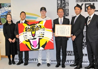 賞状と記念品のアクリル画を受け取った中野拓夢選手（左から３人目）と粟井一夫球団社長（同４人目）＝２５日午前、兵庫県庁