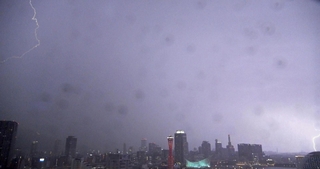 激しい雨に続いて、神戸港の上空に稲妻が走った＝２５日夜、神戸市中央区東川崎町１から東を望む