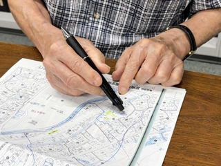 原爆症認定訴訟の原告男性。被爆した長崎市西山町の実家を地図で確認した＝神戸市中央区