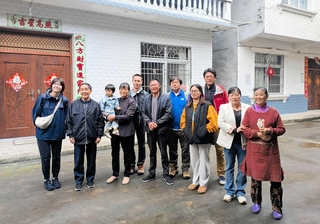 交流を続ける旧光明村の住民と記念写真に納まる吉椿雅道さん（右から５人目）、山村太一さん（同７人目）、安福瑞希さん（左端）＝中国・四川省北川県（ＣＯＤＥ海外災害援助市民センター提供）