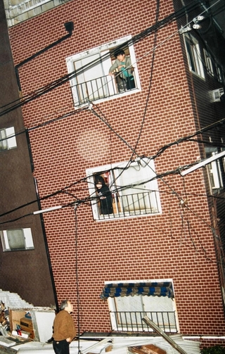 地震直後、倒壊しそうな建物から救助を待つ住民ら＝神戸市兵庫区、１９９５年１月１７日