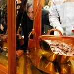 てんびんで硬貨の重さを慎重に計る職員＝大阪市北区天満１