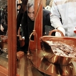 てんびんで硬貨の重さを慎重に計測する職員＝大阪市北区天満１