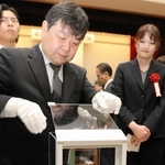 電子てんびんで記念貨幣の重さを計る職員＝大阪市北区天満１