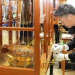 鍋のような分銅に入れた硬貨の重さをてんびんで慎重に計る職員＝大阪市北区天満１