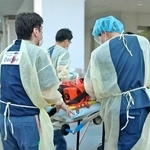 ドクターヘリで搬送されてきた患者を病院内に運び入れるスタッフら＝加古川市神野町神野、兵庫県立加古川医療センター