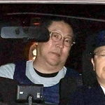 警察車両で送検される立花孝志容疑者（中央）＝１０日、神戸市中央区下山手通５