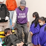 ポートアイランド住宅で階段避難車を体験する中学生ら＝神戸市中央区港島中町３