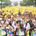 神戸マラソンのスタート地点で黄色い手袋を着け、両手を上げるランナーたち＝２０２４年１１月１７日、神戸市中央区