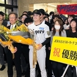 兵庫県職員らから祝福の花束を受け取った中野拓夢選手と粟井一夫球団社長＝２５日午前、神戸市中央区