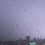 激しい雨に続いて、神戸港の上空に稲妻が走った＝２５日夜、神戸市中央区東川崎町１から東を望む