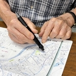 原爆症認定訴訟の原告男性。被爆した長崎市西山町の実家を地図で確認した＝神戸市中央区