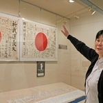 日章旗の説明をする展示の担当者＝神戸大学百年記念館