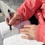 うつ病性仮性認知症と診断された女性。予定などを忘れないよう、いつもスケジュール帳を持ち歩く＝神戸市内