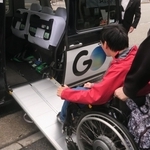 座席を折りたたみ、スロープを渡したユニバーサルデザインタクシーに乗り込む男性＝西宮市内