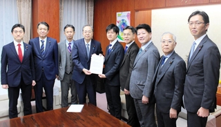 養殖カキの大量死問題で、鈴木憲和農相（右から５人目）に要望書を提出した公明党の斉藤鉄夫代表（同６人目）ら＝東京都千代田区