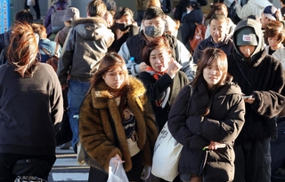 強い風が吹き、厚手の上着を着込む人が目立った＝３日午後、神戸市中央区、ＪＲ三ノ宮駅前（撮影・笠原次郎）