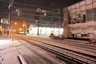 豊岡市街では３日午後８時ごろから断続的に大粒の雪が降り、数時間で１～数センチ積もった。道行く人の姿はほとんどなく、乗用車はスリップしないよう徐行した＝３日午後11時15分、同市若松町