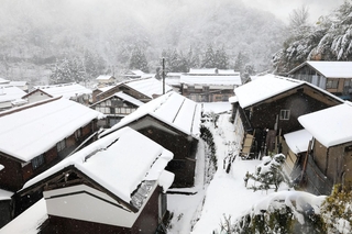 集落の多くの屋根に雪が降り積もった＝４日午前、香美町村岡区熊波