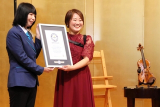 ギネス世界記録の認定証を受け取る伊藤真波さん（右）＝神戸市西区