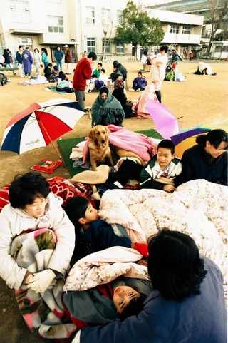 学校へ避難した人たち。寒さの厳しい季節に校庭で身を寄せた＝神戸市須磨区、１９９５年１月１７日