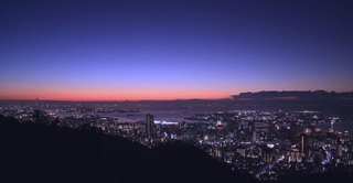 厳寒期ならではのかぎろい。日の出前の空を赤から濃紺の階調を描いて染め上げる＝１６日未明、神戸市中央区、市章山から望む