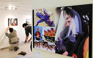 関西写真記者協会の新人賞作品「守るべきもの、瞳の先に」などの写真が設営される報道展の会場＝１７日午後、神戸市中央区、さんちかホール