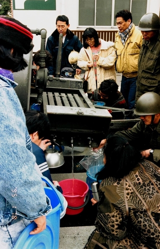断水が続き、自衛隊の給水タンクからバケツに水を入れて運んだ＝１９９５年１月１８日、神戸市中央区