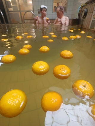 冬至に合わせて提供されたゆず湯を楽しむ人たち＝２２日午後、神戸市灘区備後町３