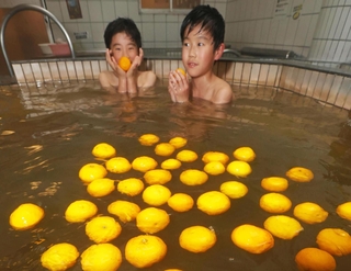 冬至に合わせて提供されたゆず湯を楽しむ子どもたち＝２２日午後、神戸市灘区備後町３