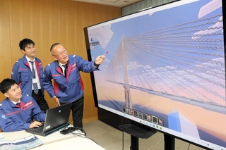 国土交通省浪速国道事務所がマインクラフトで制作した海上長大橋の画面を紹介する職員ら＝大阪市西区九条南