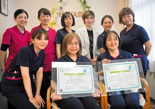 「国際出産イニシアティブ」の関西初の認証医院になった林産婦人科の藤井治子院長（前列中央）とスタッフら。手にするのは認証書＝神戸市須磨区行幸町４