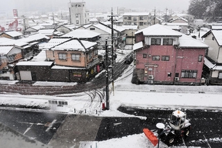 雪が降る中、除雪作業にあたる車両＝２６日午前、朝来市、朝来市役所前（撮影・小日向務）